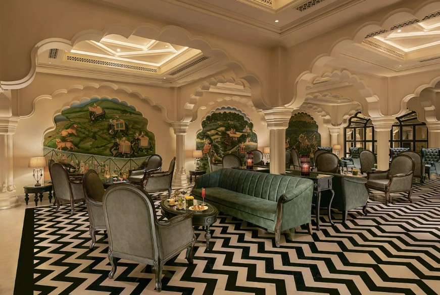 Lounge with hand-painted murals, mirrored niches and a striking chevron floor — a pared-back, contemporary nod to palace tradition.