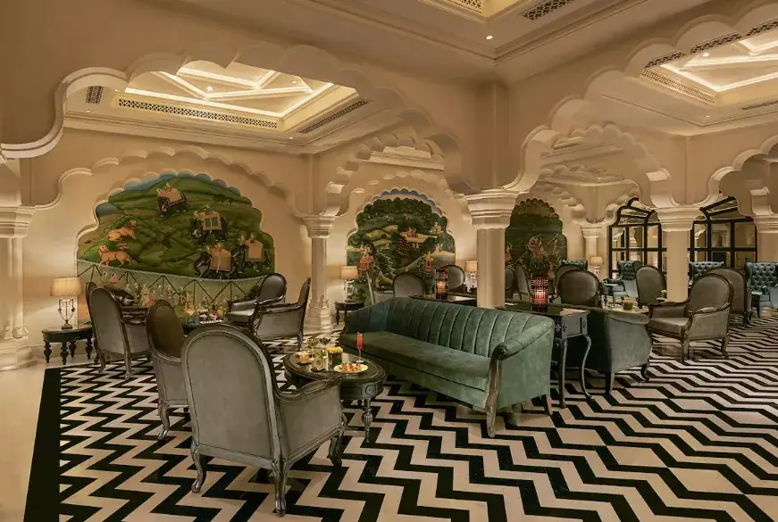 Lounge with hand-painted murals, mirrored niches and a striking chevron floor — a pared-back, contemporary nod to palace tradition.