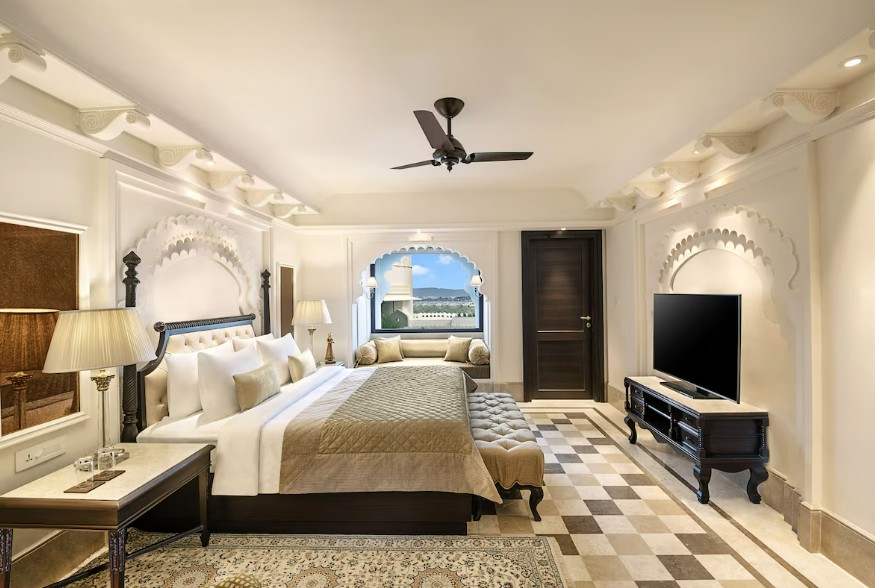 A room in calm beige and cream tones with carved arches and a window-seat niche that draws the gaze outside.