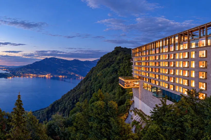 El Bürgenstock Hotel & Alpine Spa sobre la cresta montañosa, muy por encima del lago de los Cuatro Cantones al anochecer