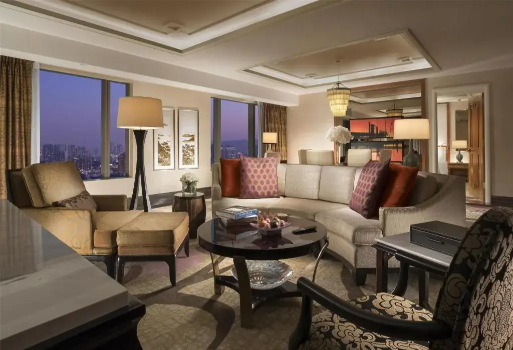 Suite con zona de estar y vistas sobre Cotai al atardecer, Conrad Macao.