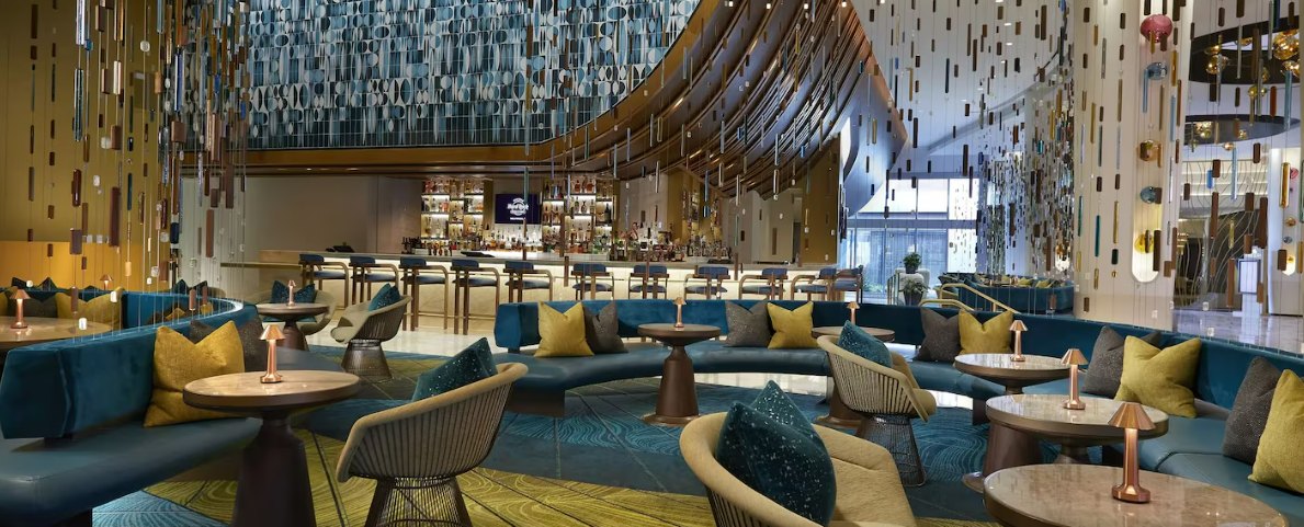 A lobby bar beneath a sculptural ceiling installation — inside, too, the staging remains part of the product.