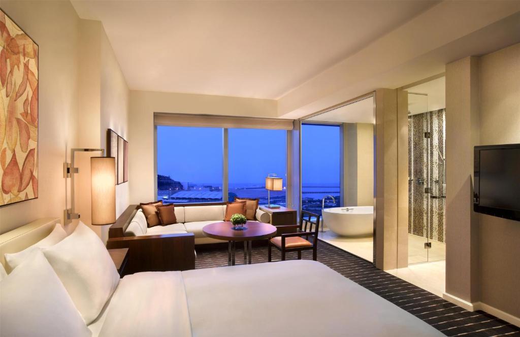 Habitación con zona de estar y ventanales panorámicos.