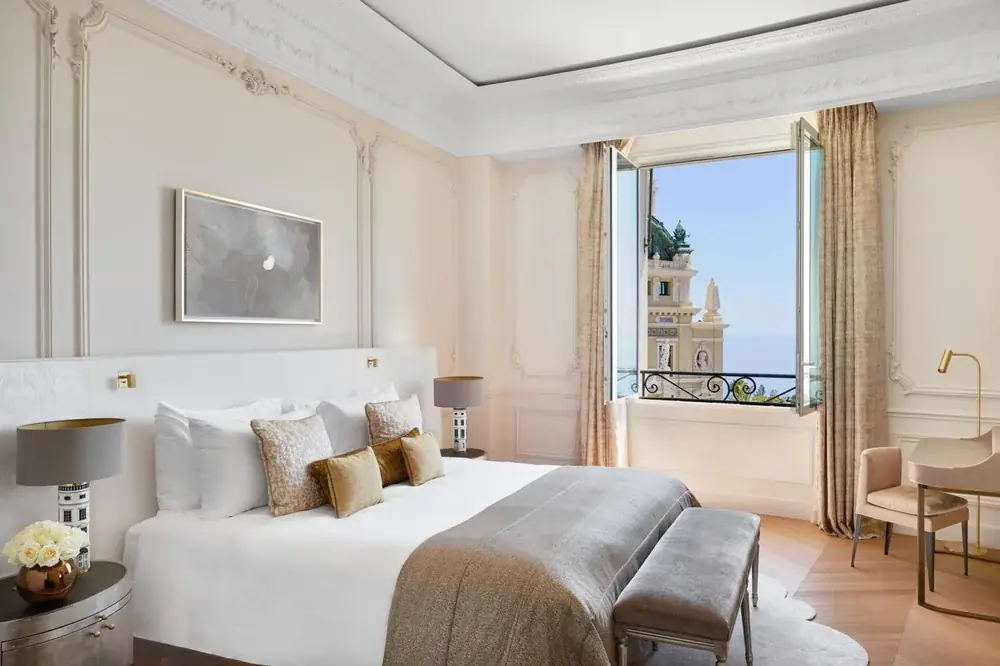 Schlafzimmer einer Suite mit geöffnetem Fenster und Blick auf die Oper und das Meer