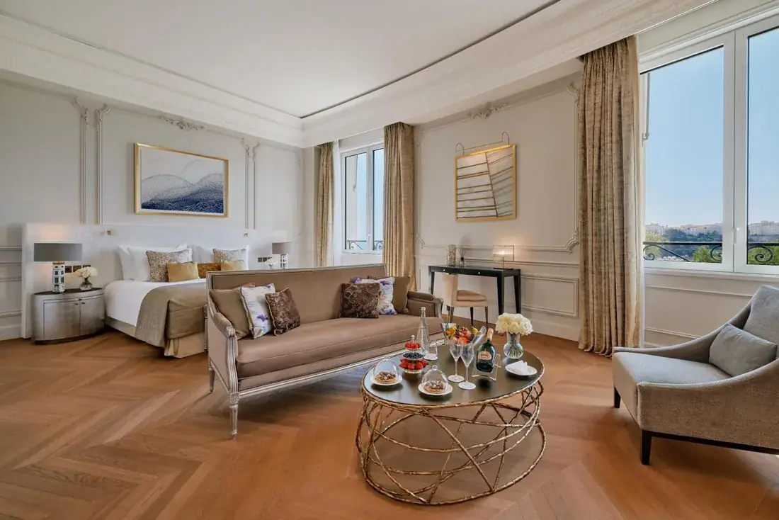 Eleganter Salon einer Suite mit Champagner, Kamin und Stuckdecke