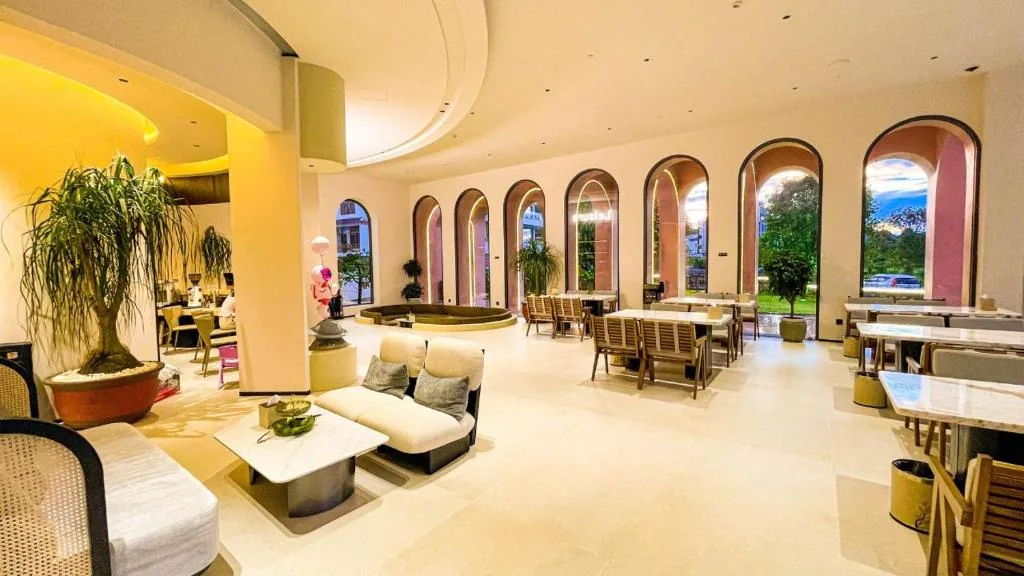 Lobby- und Restaurantbereich mit hohen Rundbogenfenstern und heller, weicher Gestaltung.