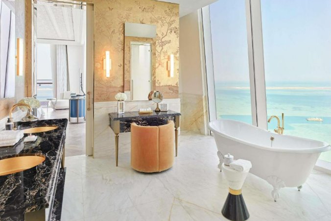 Suiten-Bad mit freistehender Wanne und Blick auf den Golf — das Erlebnis reicht bis in die privatesten Bereiche.