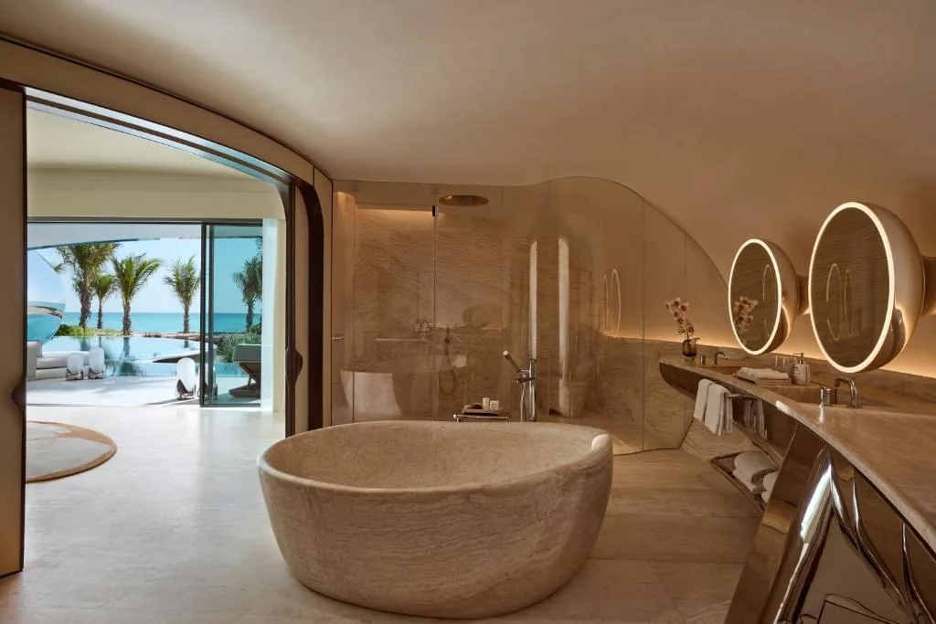 A natural-stone bathroom with sea view — materials and fit-out are created in the factory, so the intervention on site stays small.
