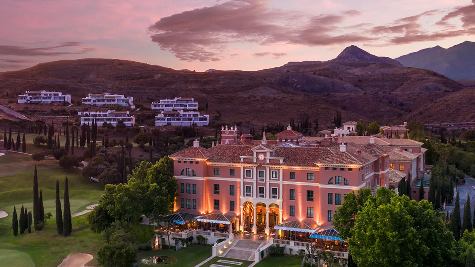 Anantara Villa Padierna Palace near Marbella at dusk, surrounded by golf courses and cypress trees