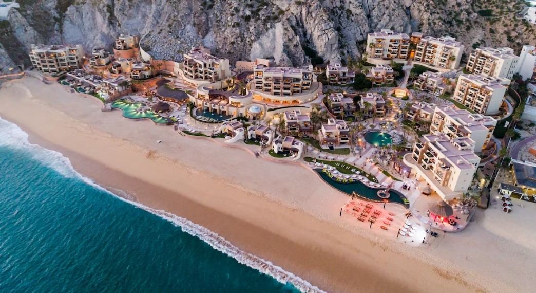 Das Resort schmiegt sich zwischen Felsen und Strand an die Küste — niedrige Baukörper statt eines monumentalen Blocks.